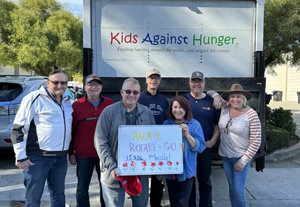 Rotarians volunteering to pack food for Kids Against Hunger.