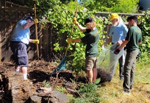 Rotarians working with scouts from Troop 911 removing debris during spring cleaning event.