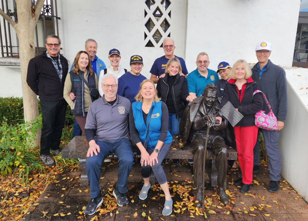 Rotary Club of Pleasanton volunteers sit in front of veterans memorial building.